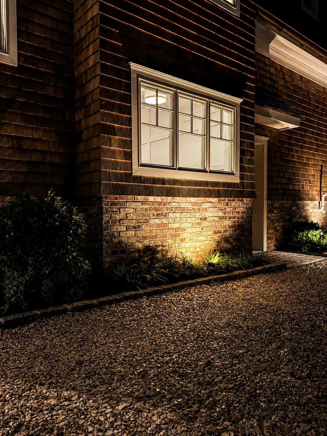 Professional outdoor uplighting highlighting brick and shingle details